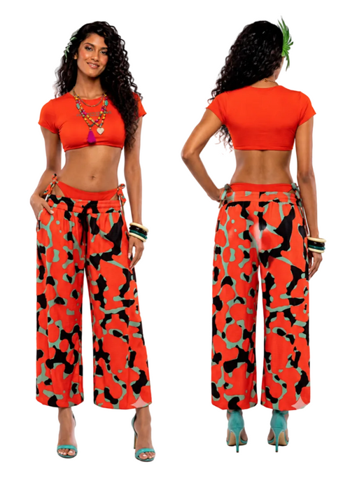 A model shown from the front and back wearing a bright orange-red crop top and matching wide-leg pants with a black and green abstract pattern, against a plain white background.