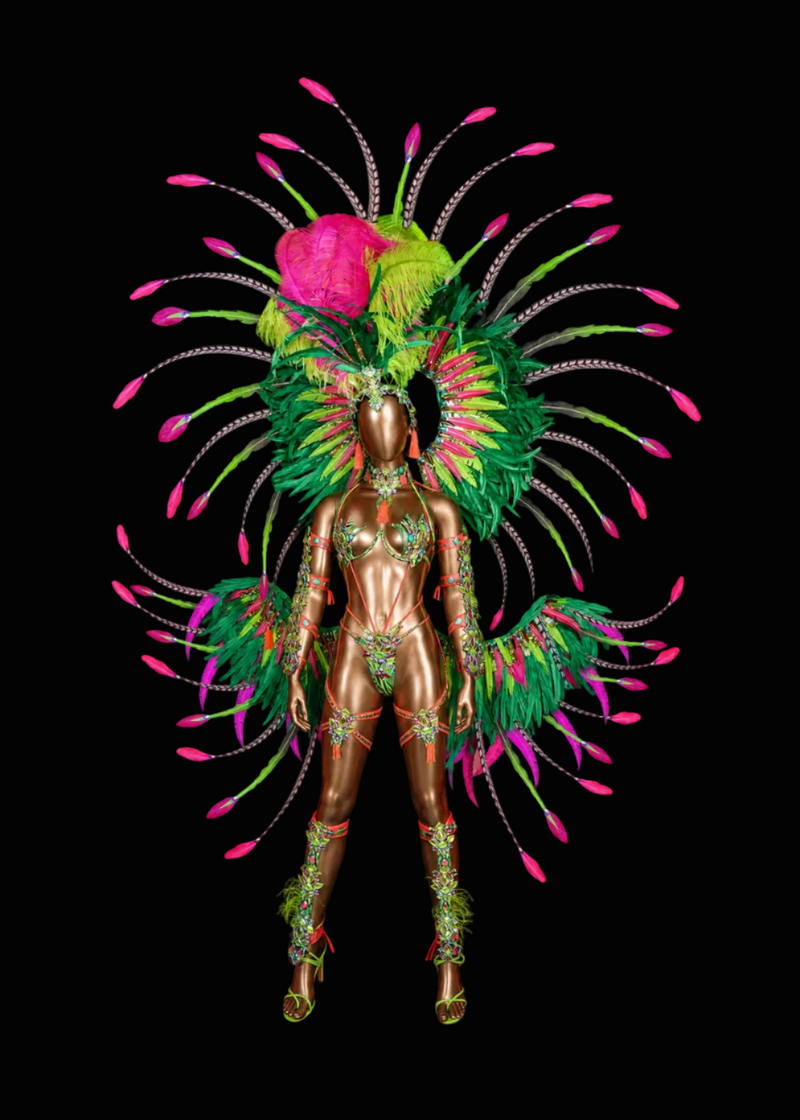A metallic bronze mannequin wearing an elaborate carnival costume with a large feathered headdress and matching feathered shoulder pieces in green, pink, and yellow, set against a solid black background.