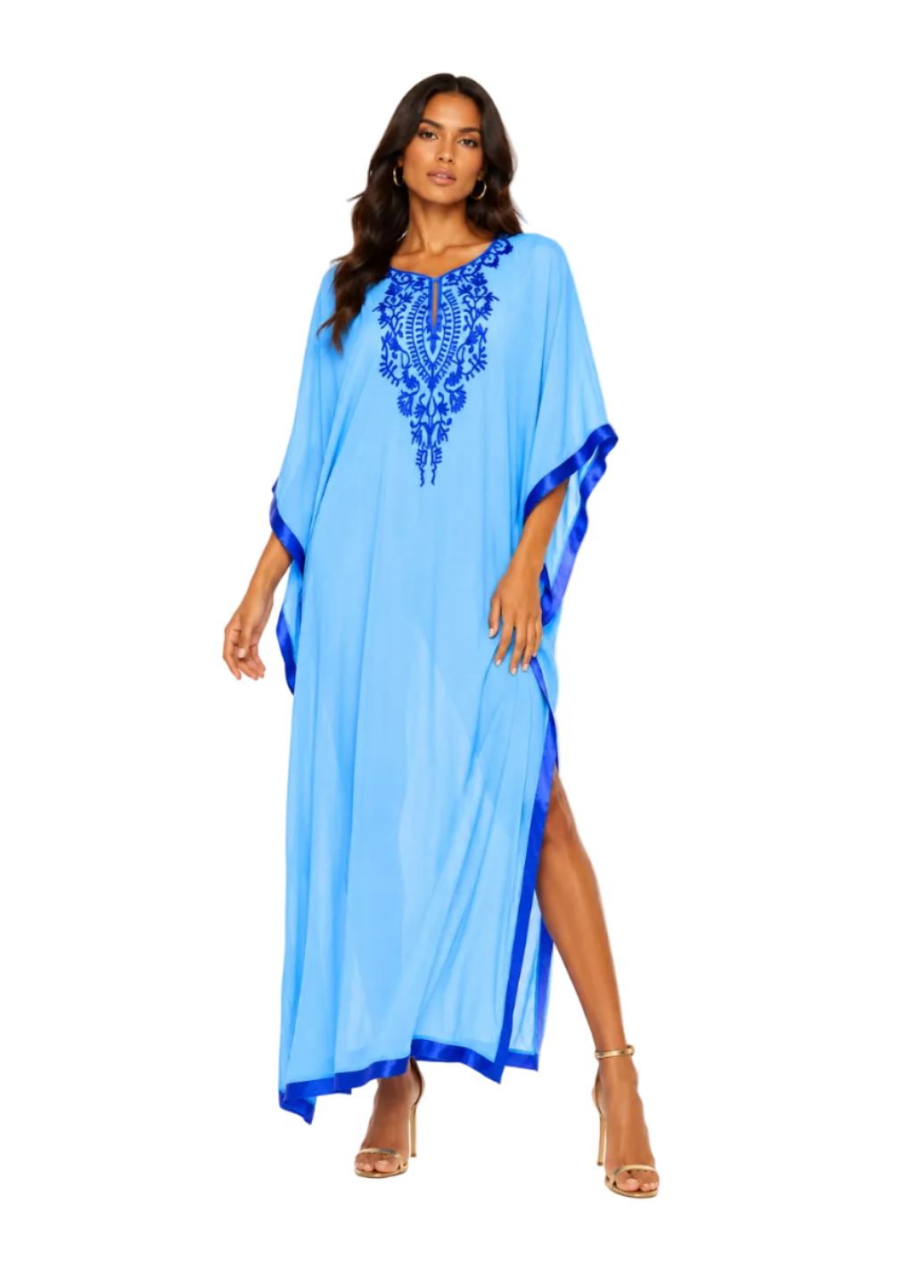 A woman modeling a light blue kaftan dress with royal blue embroidery on the chest and blue trim along the sleeves and side slit, photographed against a plain white studio background.