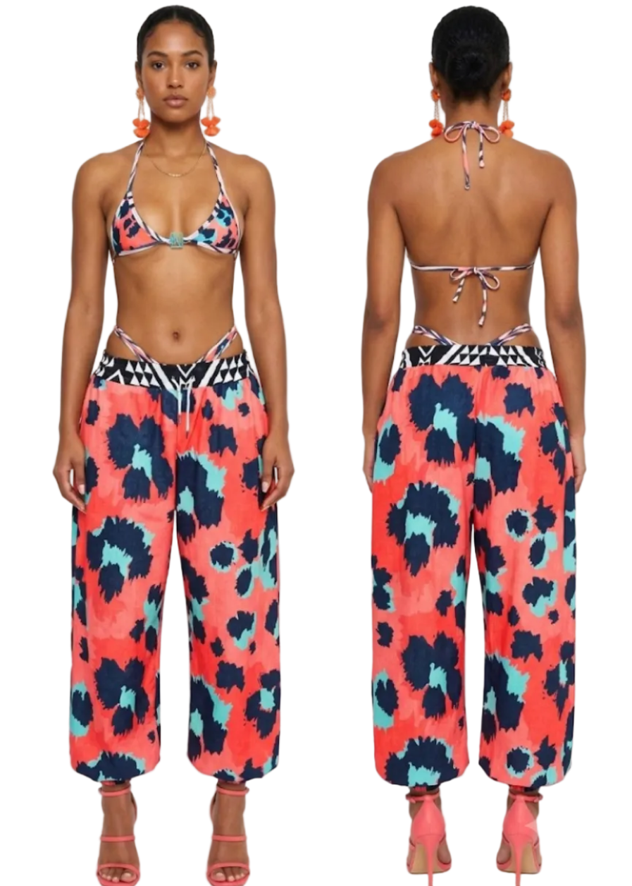 A model shown from the front and back wearing a two-piece swim set with a coral, navy, and light blue abstract print, including a halter bikini top and matching wide-leg harem pants.