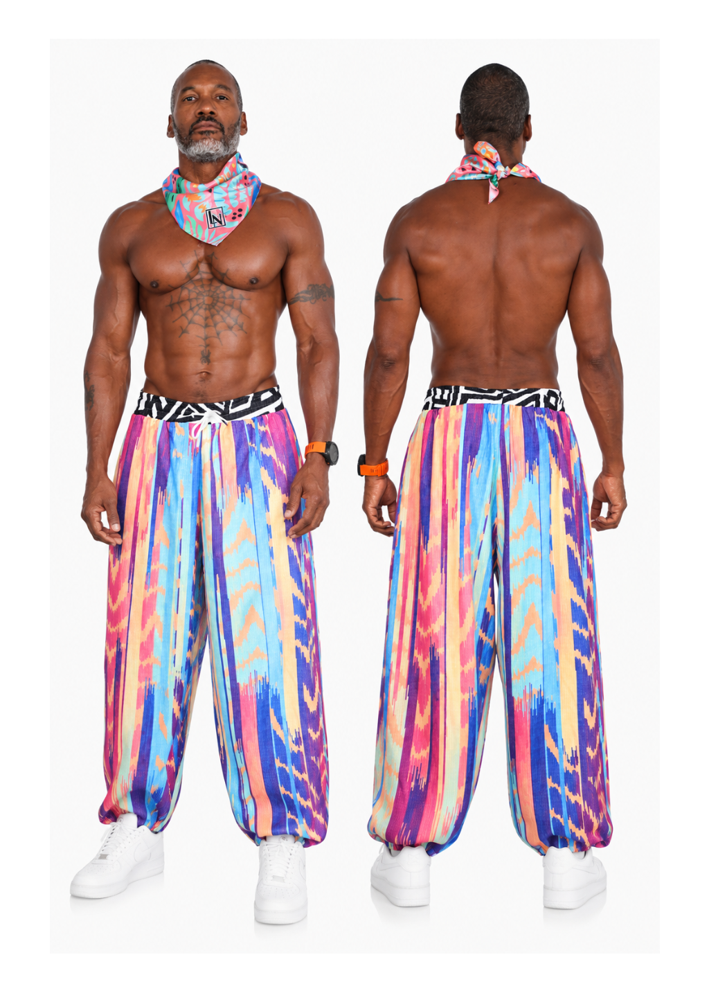 A shirtless male model shown from the front and back wearing colorful patterned harem-style pants with a black and white patterned waistband and a matching multicolor neck scarf, against a plain light background.